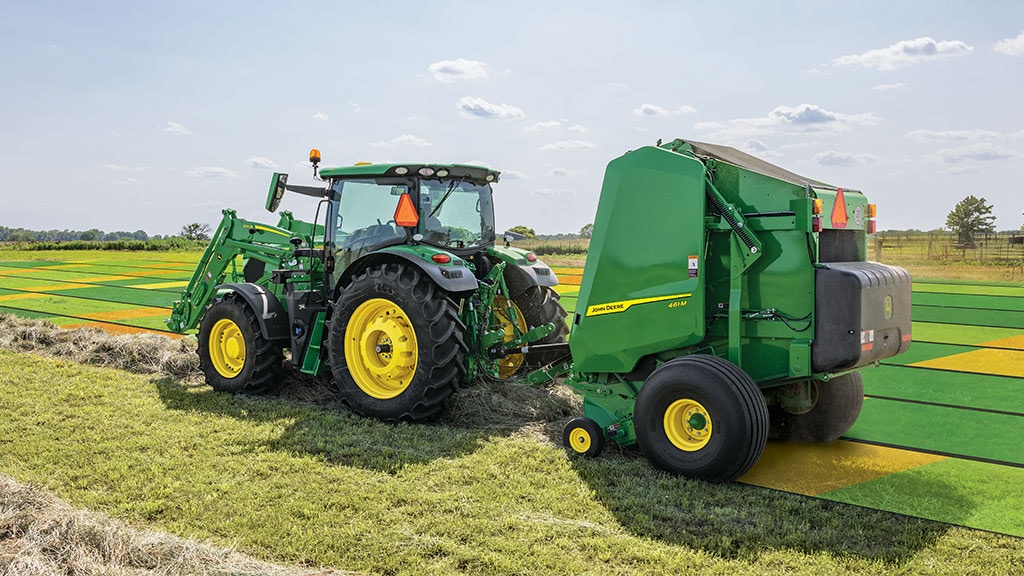 Tracteur et presse effectuant une mise en balles dans un champ de foin avec cartographie sur le terrain