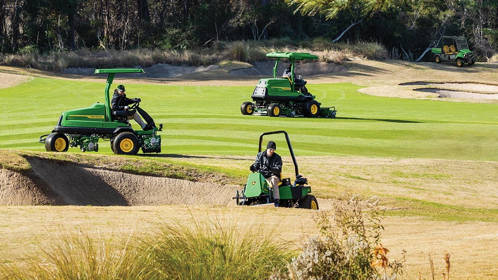 3 people maintaining a golf course with 3 different types of equipment