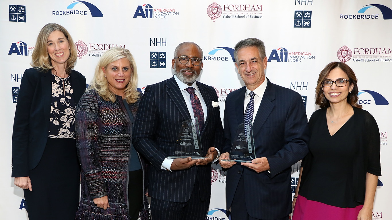 Employees in front of a backdrop at a gala accepting this award