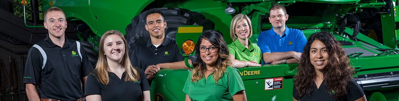 Group of employees around a tractor