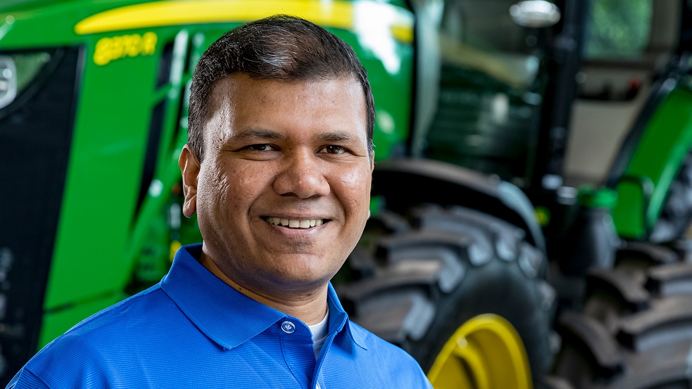 Male employee standing proudly in front of equipment