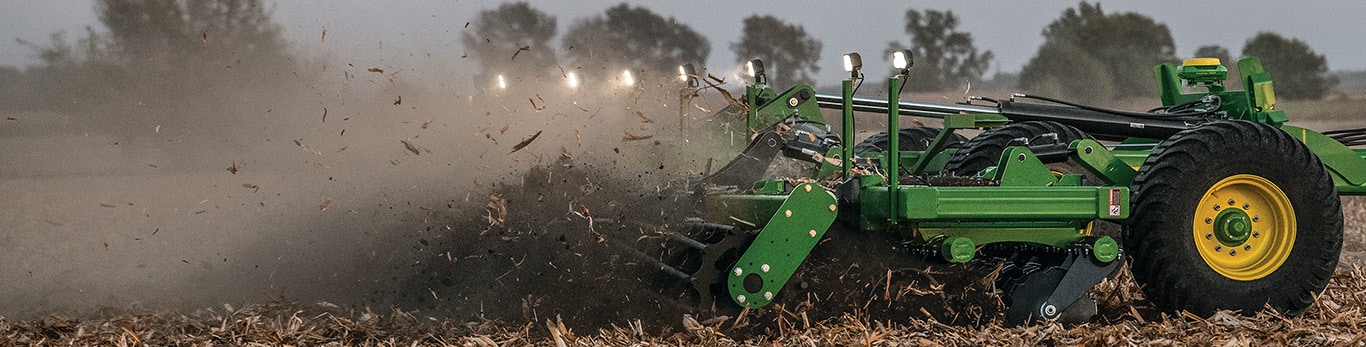 Gros plan de l&rsquo;&eacute;quipement de travail du sol &eacute;jectant le sol et les r&eacute;sidus de r&eacute;colte lorsqu&rsquo;il est tir&eacute; &agrave; travers un champ.