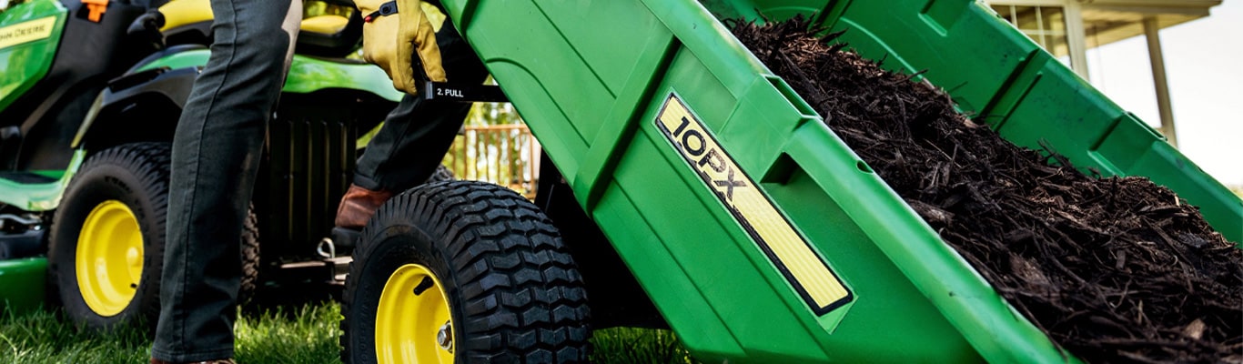 image of lawn mower with cart dumping mulch