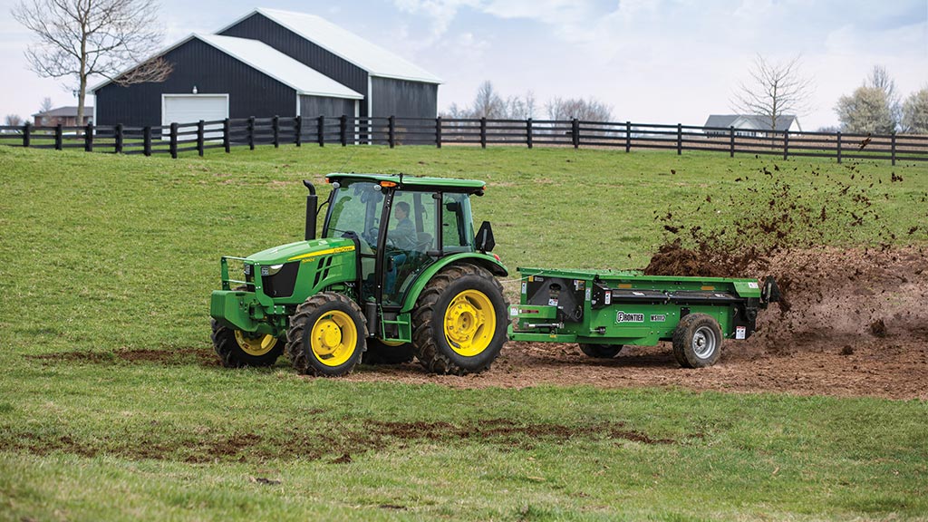 Frontier Livestock attachments being used by a John Deere compact tractor