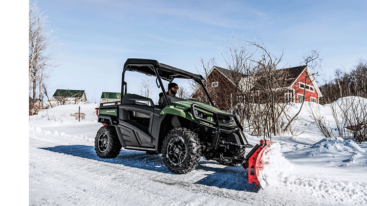 Personne déblayant la neige avec un véhicule utilitaire Gator™ équipé d’une lame