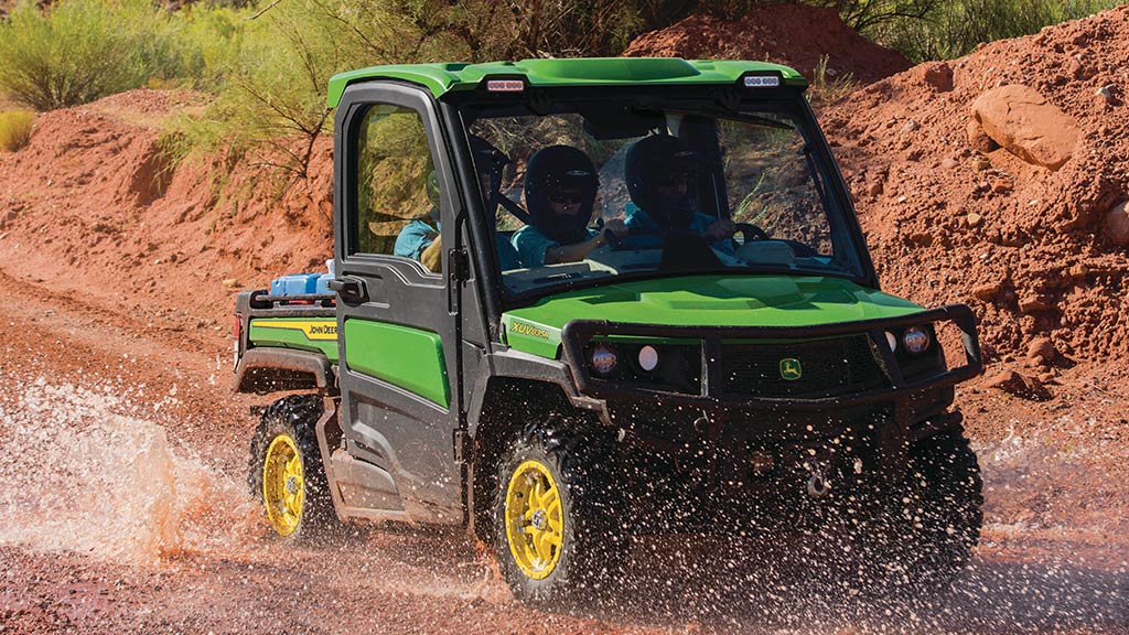 véhicule Gator™ pleine grandeur qui roule sur une piste boueuse et détrempée