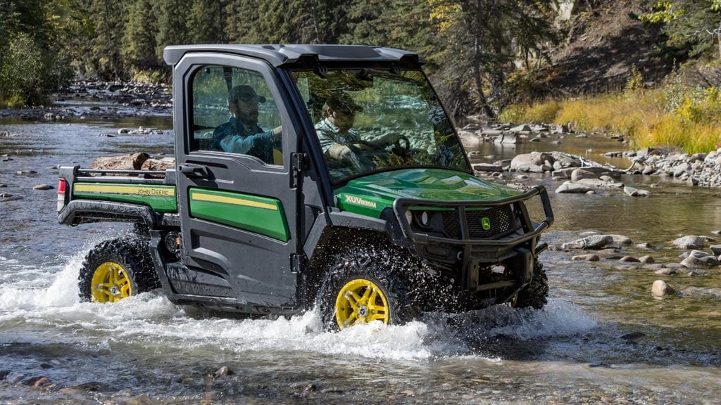 Image d'un véhicule utilitaire Gator dans un champ entouré de montagnes