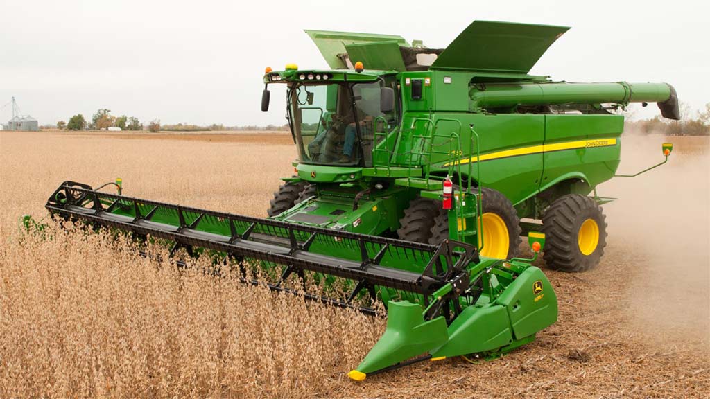 Photo d’une moissonneuse-batteuse John Deere récoltant de petits grains avec une plate-forme de tarière.