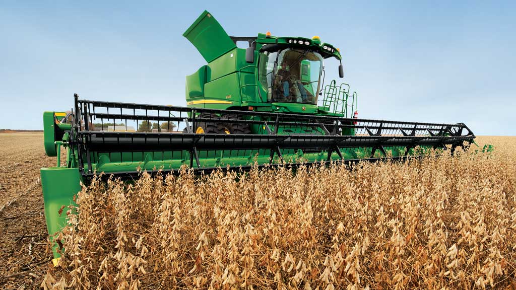 Photo d’une moissonneuse-batteuse John Deere récoltant des céréales à petits grains avec un tablier à vis.