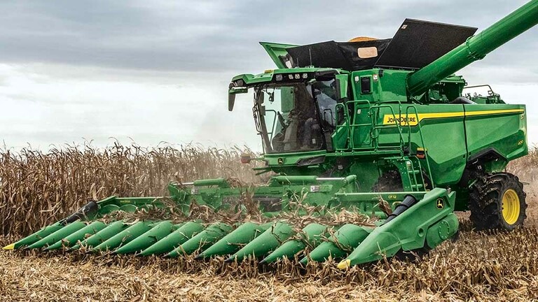 Photo de dessus d'une moissonneuse-batteuse John Deere récoltant du maïs avec un cueilleur à maïs repliable CF12