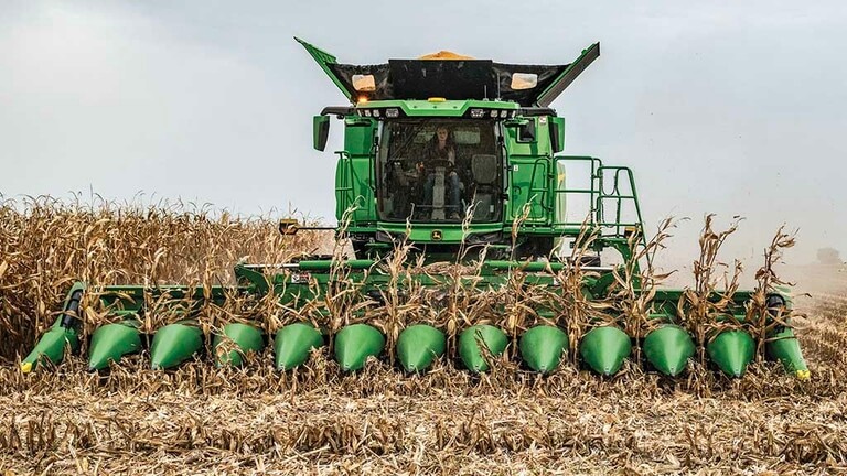 Photo frontale d'une moissonneuse-batteuse John Deere avec un cueilleur à maïs repliable CF12 partiellement déployé