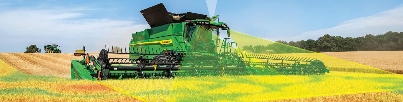 Moissonneuse-batteuse John Deere récoltant des céréales grâce à la technologie Harvest Automation, visualisée à travers le champ.