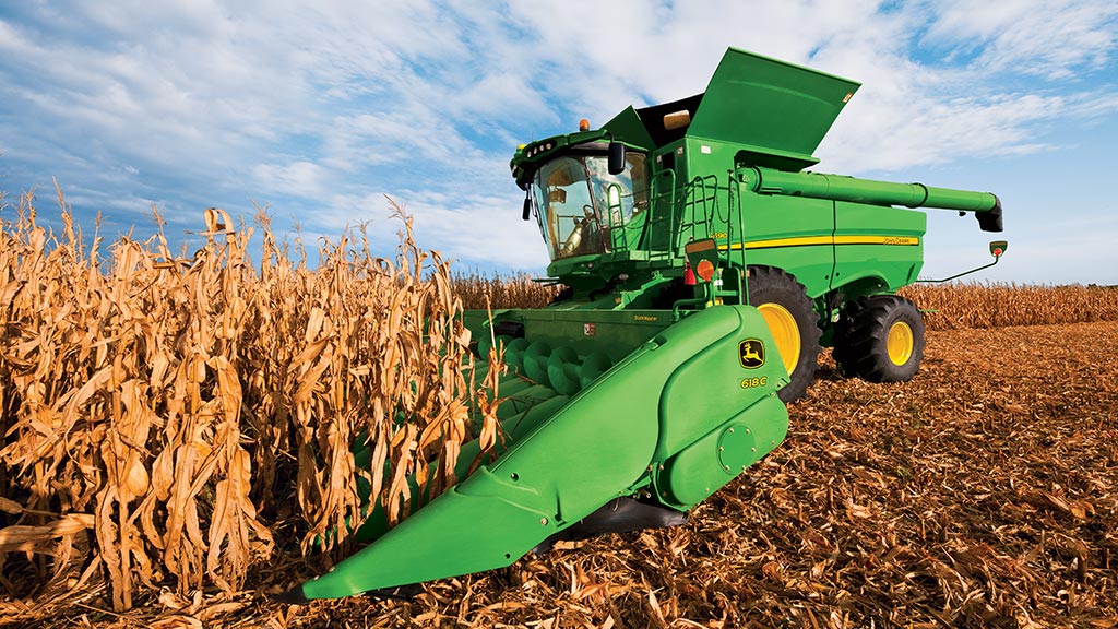 Photo d’une moissonneuse-batteuse S7 John Deere avec cueilleur à maïs terminant un passage dans un champ de maïs.