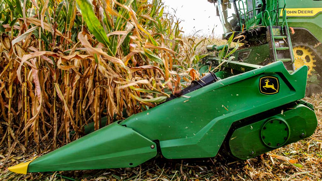 Photo en gros plan d’un nez de diviseur de cultures sur une tête de maïs John Deere.