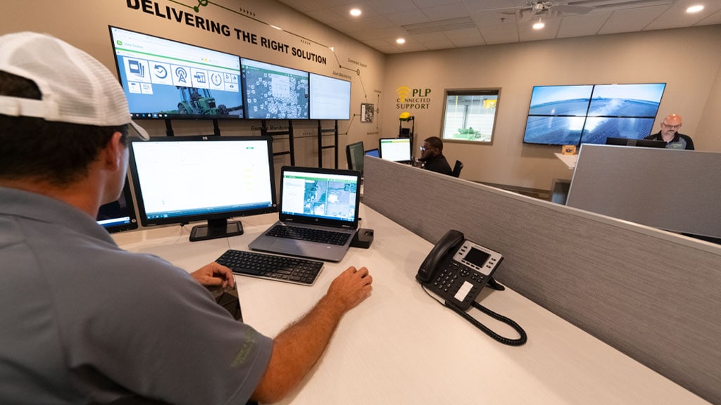 Technicien John Deere, dans un centre de support client, fournissant un support en ligne à un client.