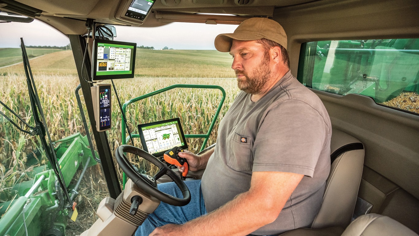 Person sitting in X Series combine cab out in the field