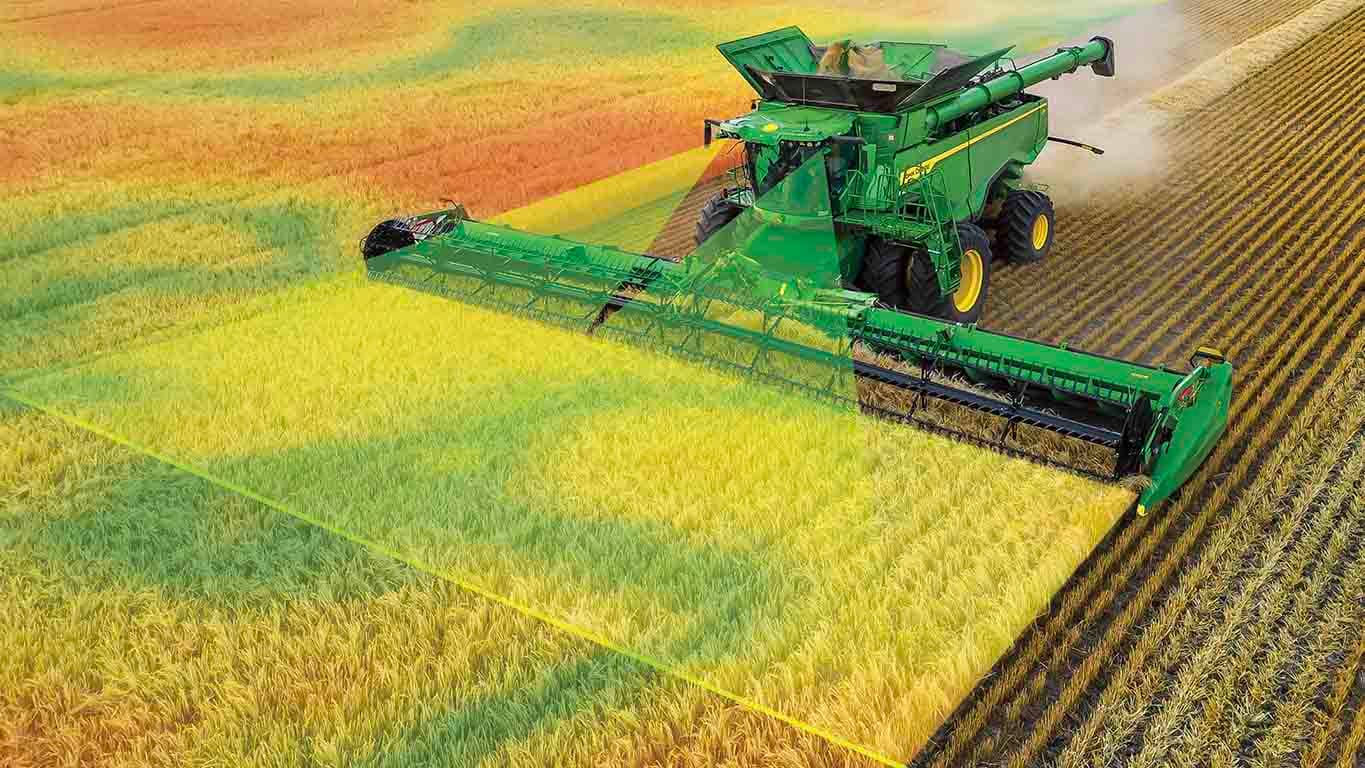 Photo of an X9 Combine harvesting wheat with a draper head. Graphics simulate front cameras scanning the crops, which comes with Predictive Ground Speed Automation
