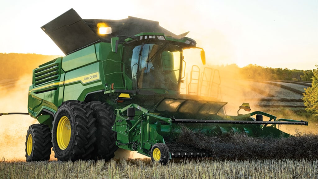 Photo of a John Deere Combine gathering windrowed grain with a BP15 Belt Pickup