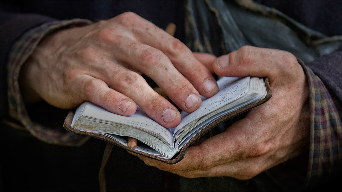 Photo of hands holding a small notebook open