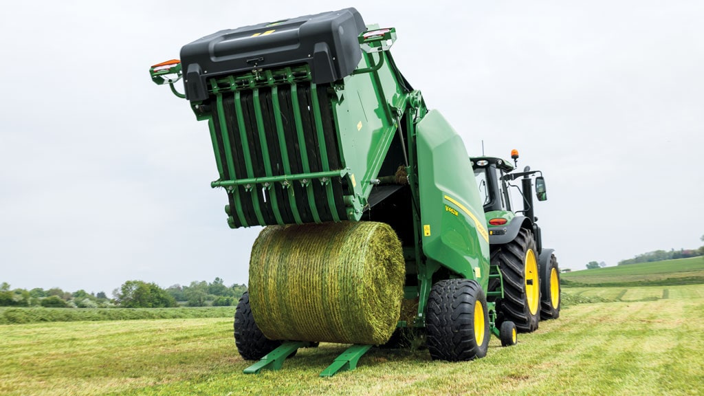 A baler over a field ejected a hay bale