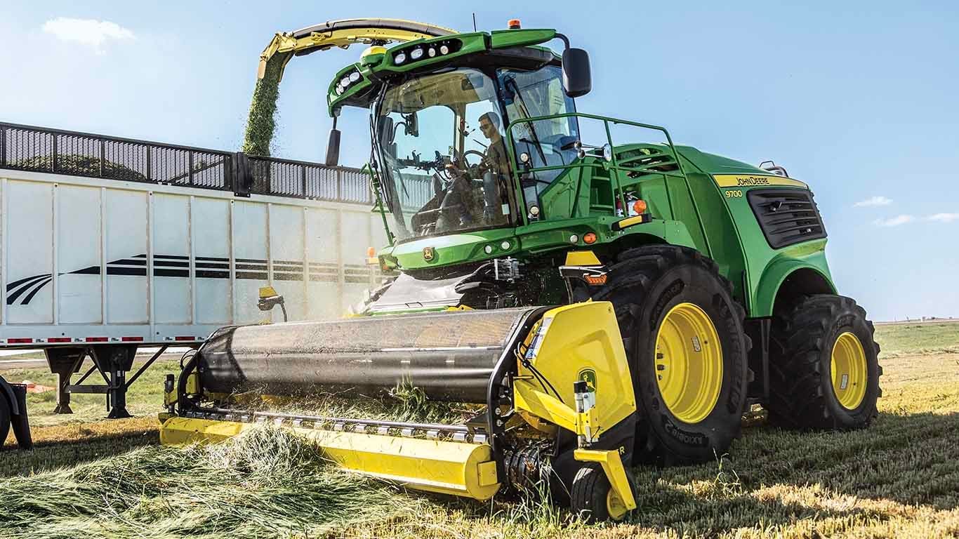 Ramasseur 46R qui récupère le foin dans un champ, puis le transfère dans une benne