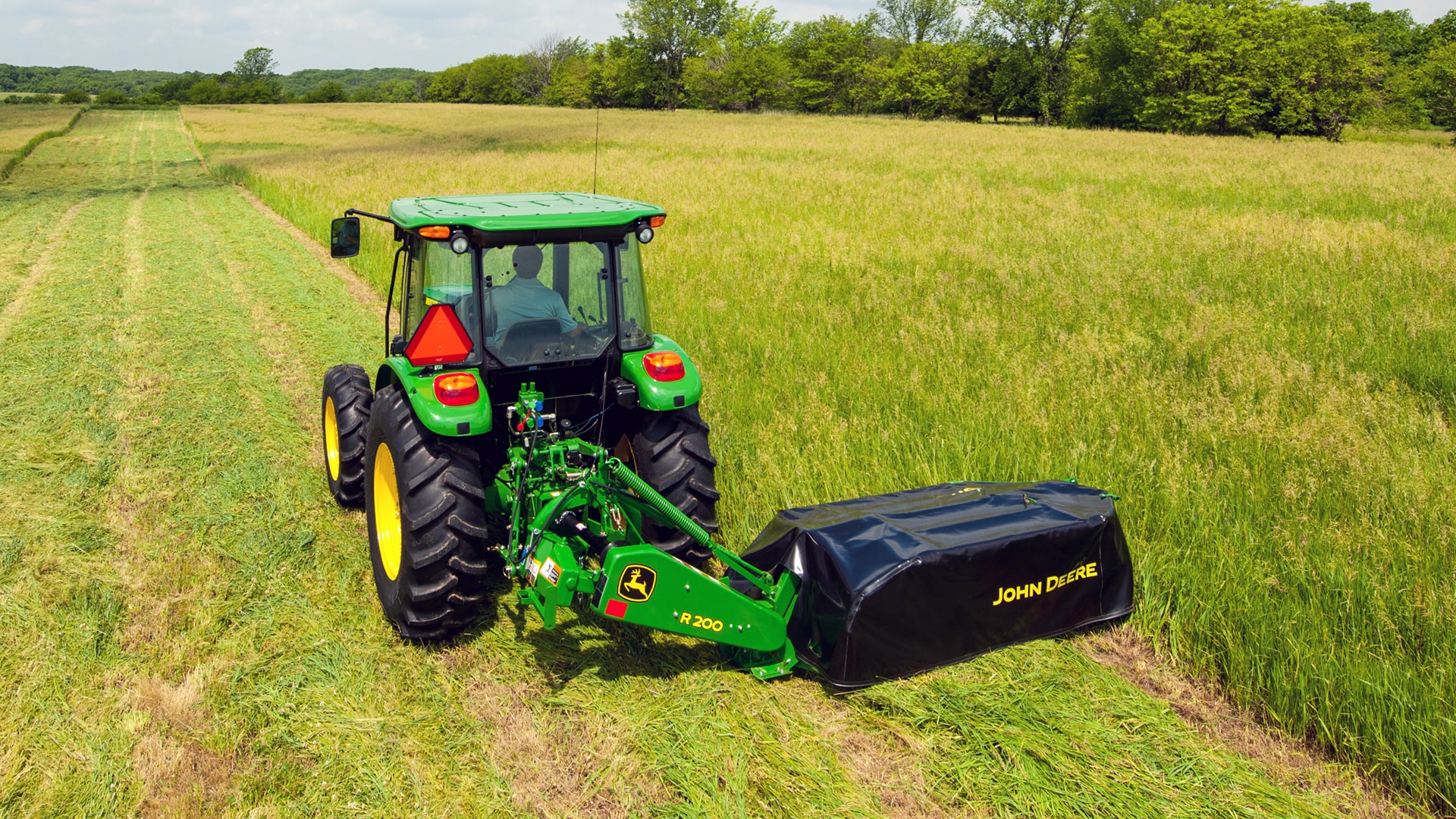 A disc mower moving through field