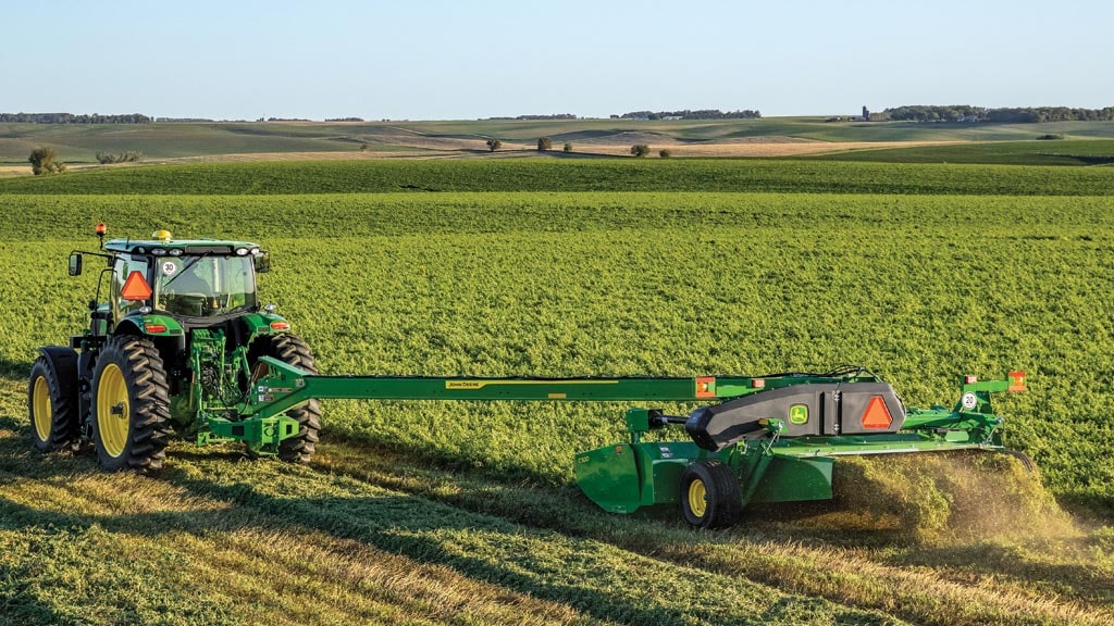 Faucheuse-conditionneuse montée sur un tracteur dans un champ