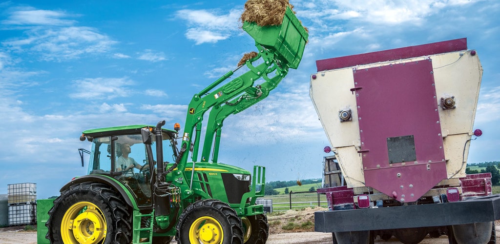 image of tractor with loader filling up truck