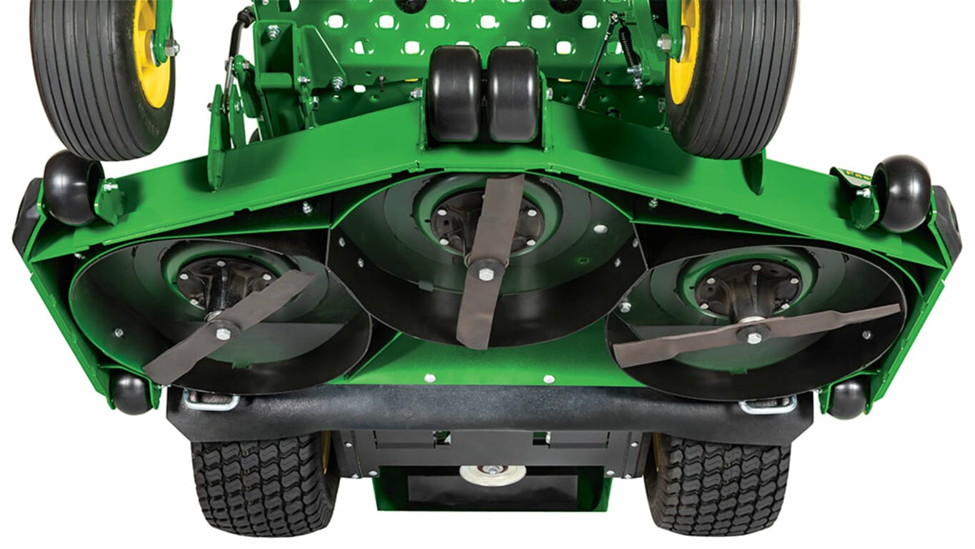 Close-up of the underside of a large green mower deck with three blades.