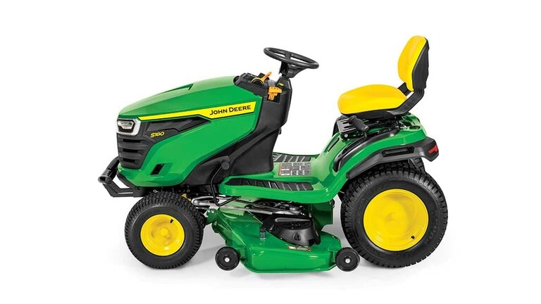 A left-facing green riding mower with a yellow seat and green mowing deck on a white background.