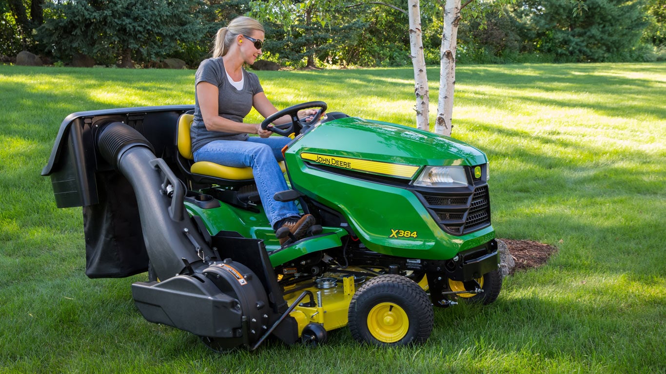 image d’une femme sur un tracteur de pelouse rattaché à un système de récupération