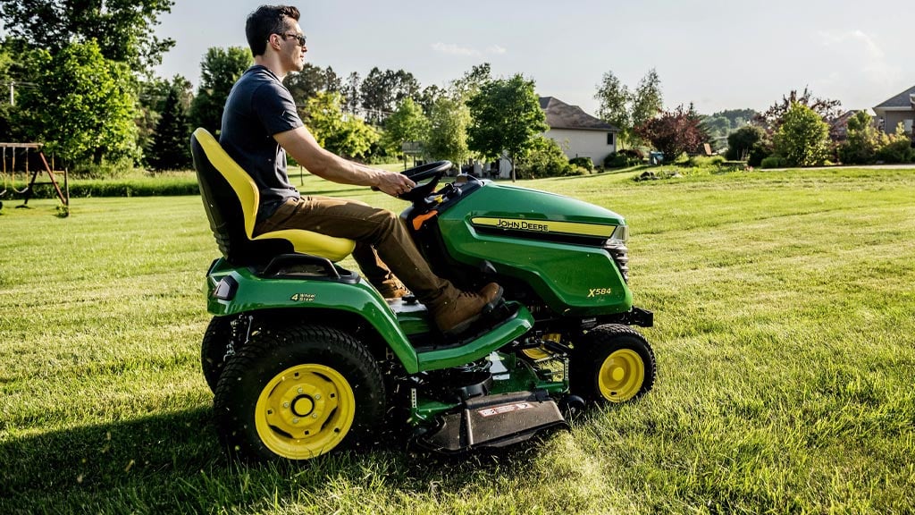 person on a lawn mower mowing grass