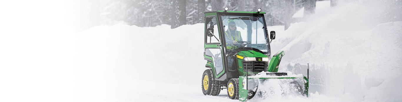 Man blowing snow using an X700 series lawn tractor