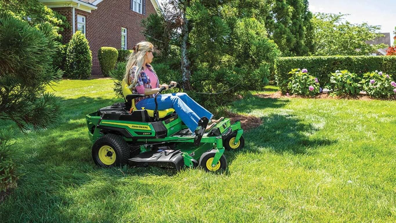 Person riding a Z320R mower near trees