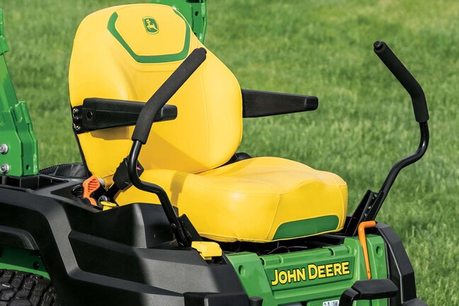 Close-up shot of a yellow seat with green details and the John Deere logo on a zero-turn mower.