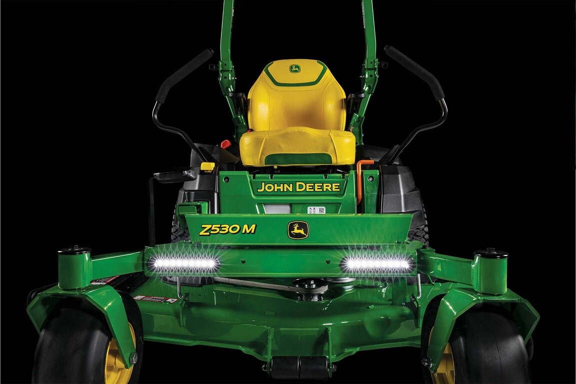 A dramatic close-up front shot of the yellow seat and LED lights on a Z530M zero-turn mower with a black background.
