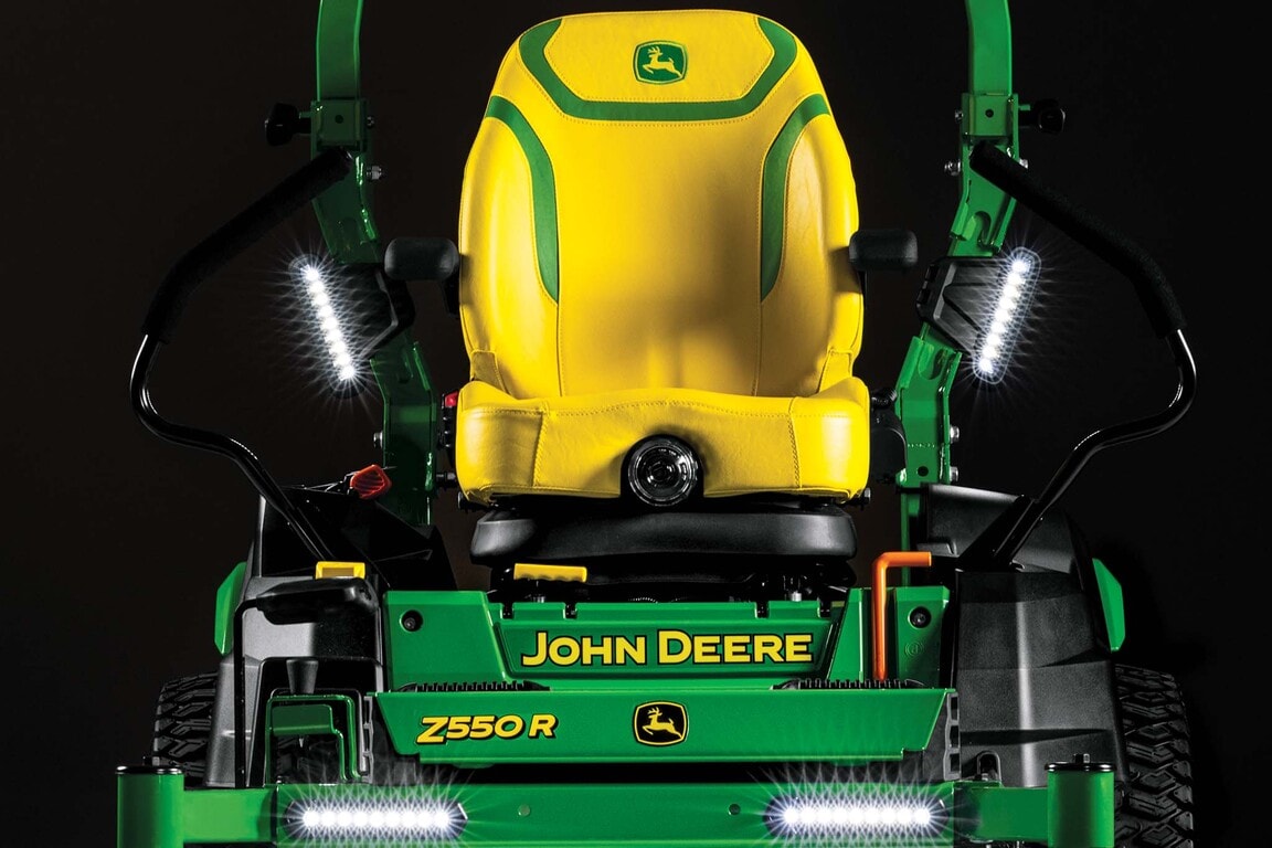 A dramatic close-up front shot of the yellow seat and LED lights on a Z550R zero-turn mower with a black background.
