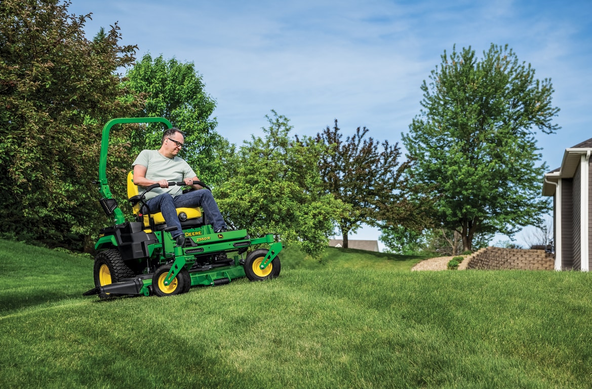 A Z550R zero-turn mower is used to mow the gentle sloped lawn of a residence.