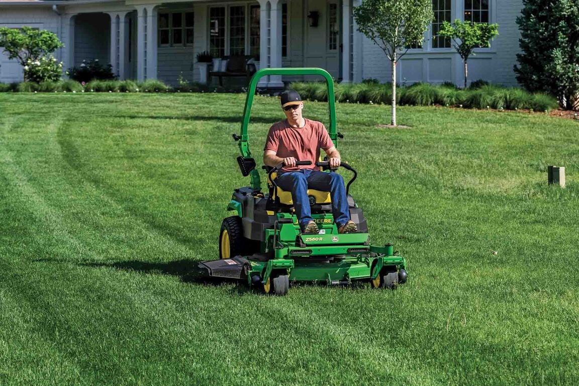 A Z560R zero-turn mower is used to mow the large front lawn of a residence.