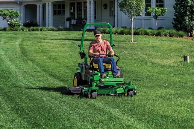 A Z560R zero-turn mower is used to mow the large front lawn of a residence.