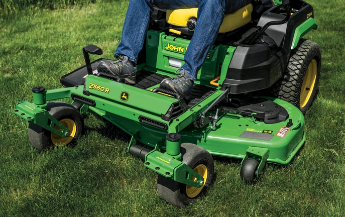 Close-up front-left-facing shot of a Z560R zero-turn mower deck and foot rest over grass.