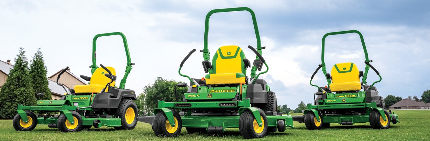 Three zero-turn mowers on a lawn