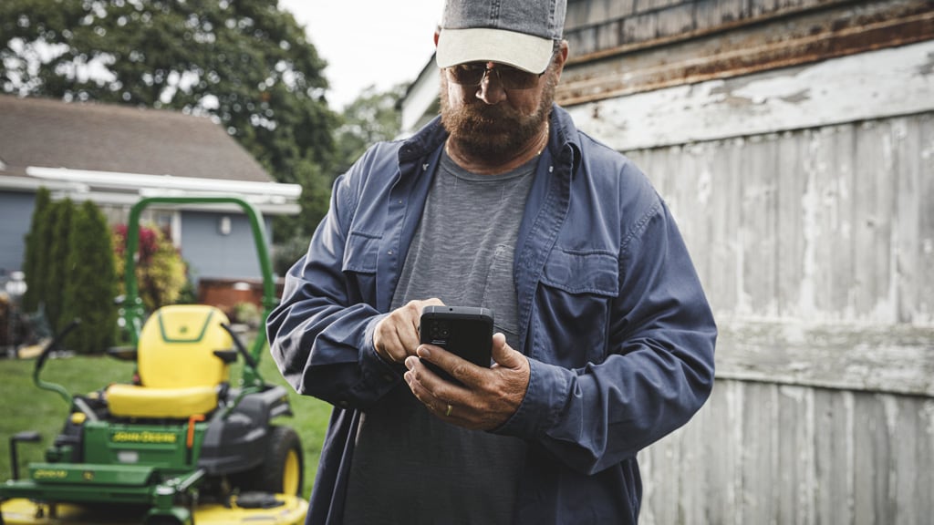 Photo d'une tondeuse John Deere avec une remorque pleine de plants