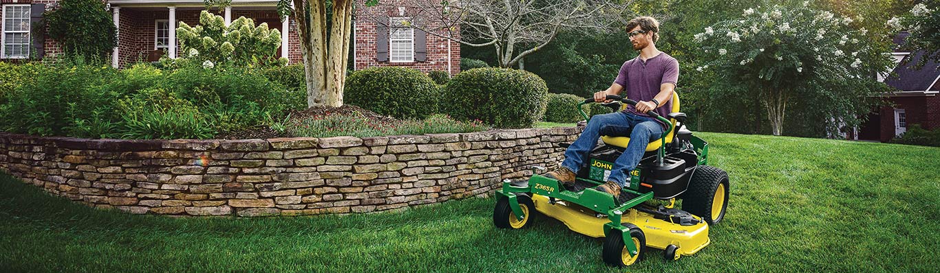 man driving z300 lawn tractor in yard