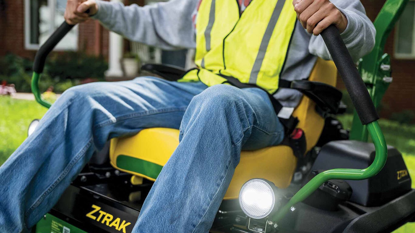 A zoomed-in shot of a landscaper operating a green Z720M zero-turn mower.