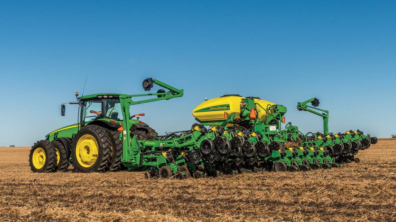 Semoir de précision John Deere tracté dans un champ