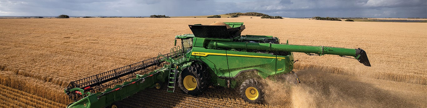 Combine with header harvesting wheat field