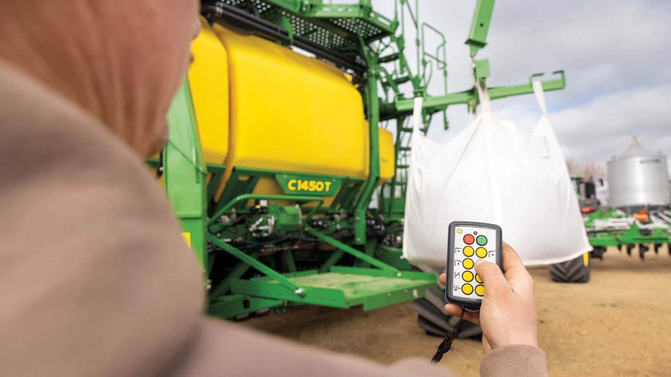 Gros plan sur le nouveau système EZLift et la plate-forme de remisage latérale sur un chariot pneumatique tracté C1450T John Deere.