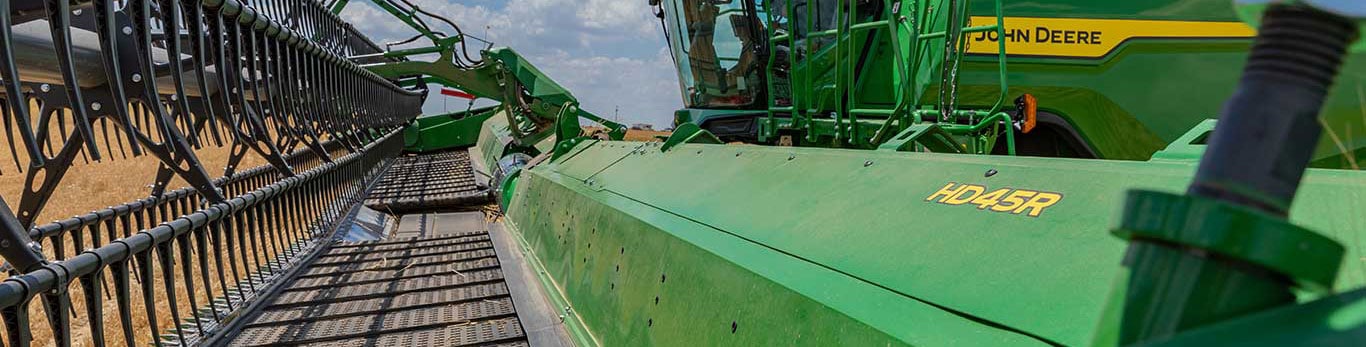 Courroies anti-pertes de grains installées sur un élément de récolte HD45R pendant la récolte.