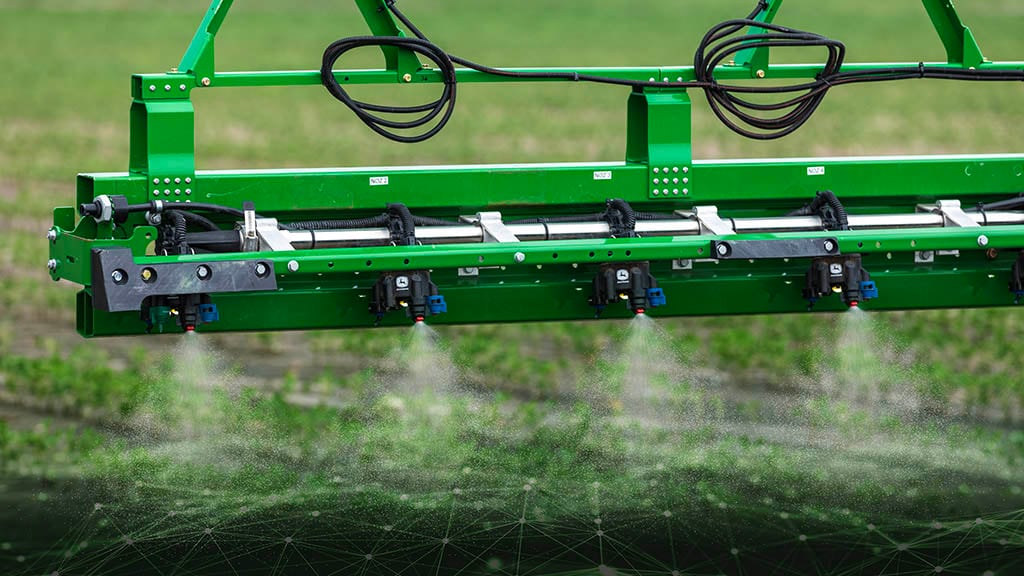 Close-up of a John Deere sprayer boom with spraying with See & Spray™ Premium Precision Upgrade.